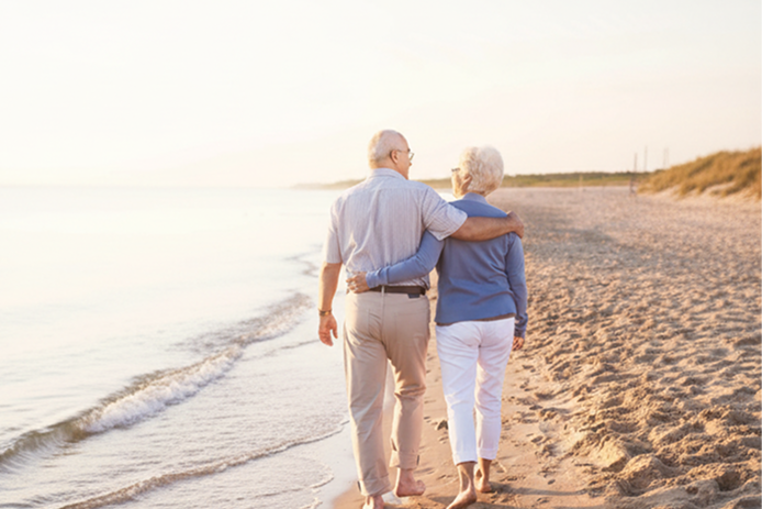 old couple walking on beach